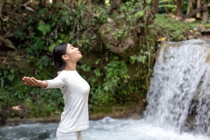 Woman standing by waterfall