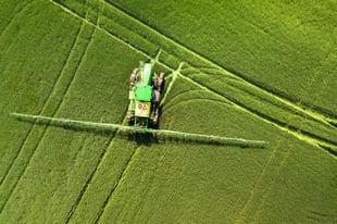 Combine spreading fertilizer on farm.