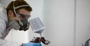 Image of a man using a compressed air paint sprayer