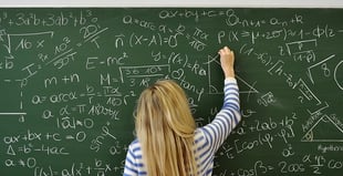 Picture of a teacher writing equations on a chalk board