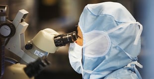 Image of a scientist looking through a microscope