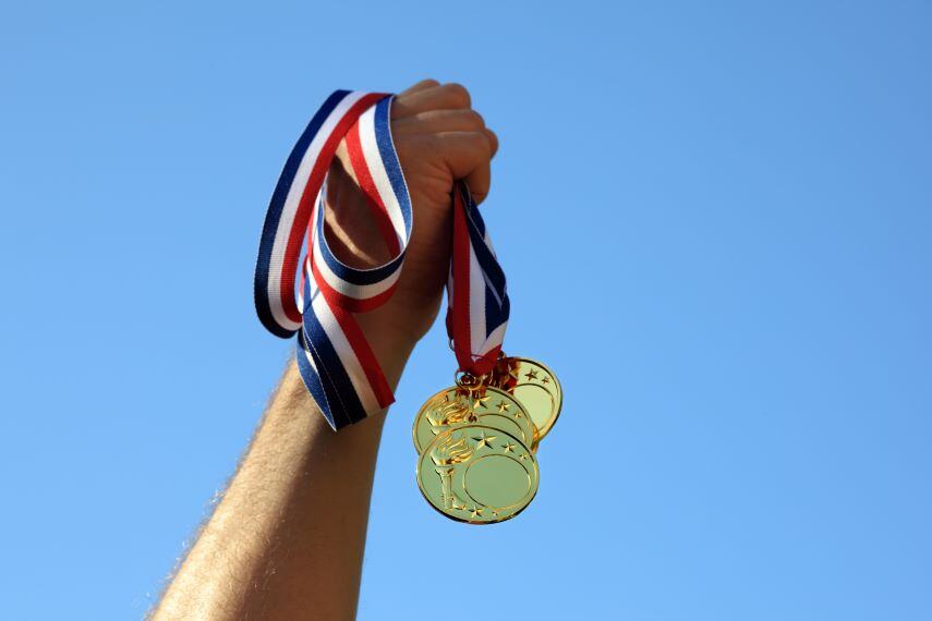 Hand holding gold medals