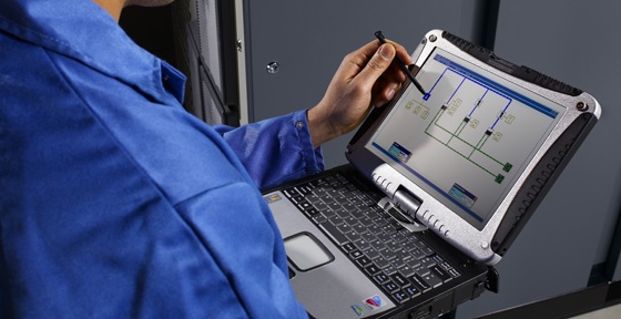 An Atlas Copco engineer checking data on a laptop