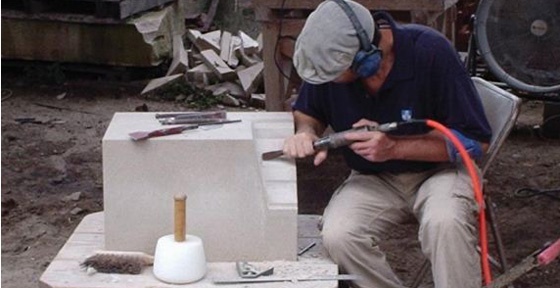 Image of a man carving stone powered by an air compressor