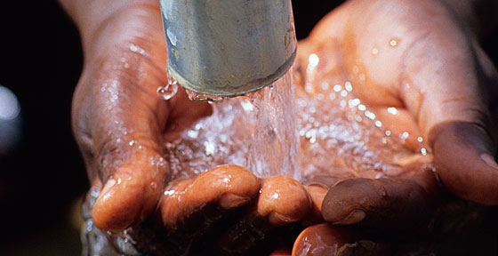 Close-up image of water pouring over someone's hands