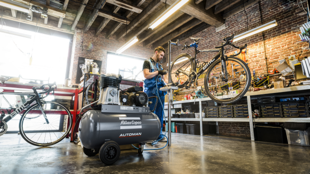 Image of an engineer fixing a bike with a compressor
