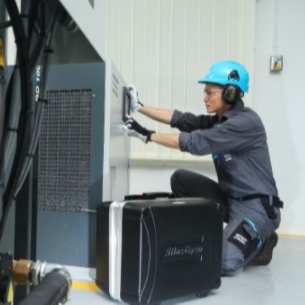 Service technician working on an air compressor