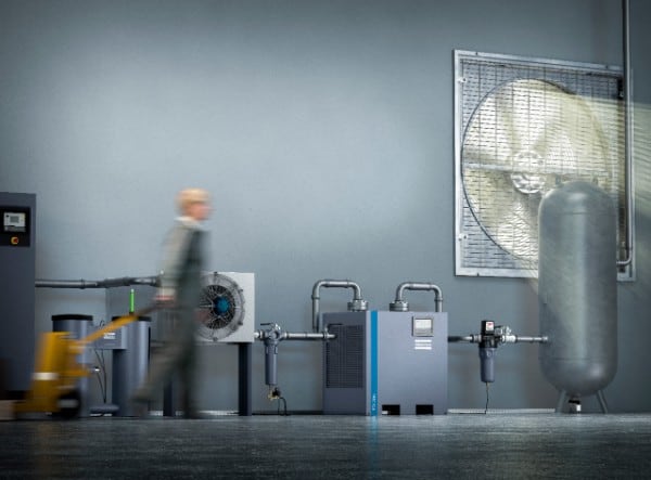 Image of an engineer walking by an Atlas Copco Air Filtration System