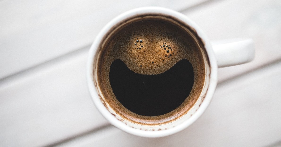 Image of a cup of coffee with a smiley face in the froth 