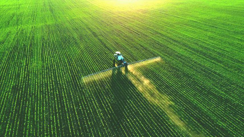 tractor spreading fertilizer on a field
