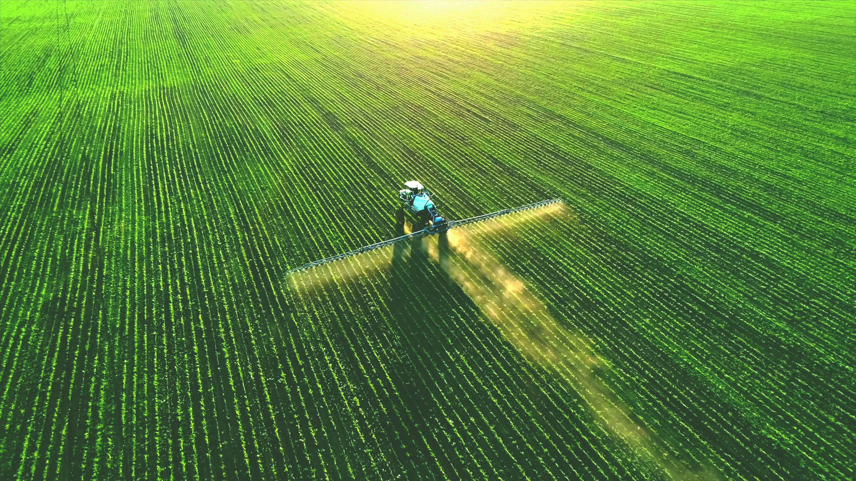 Tractor spreading fertilizer on a field